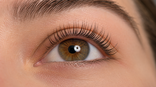Close up of one open eye showing naturally lifted lashes with a smooth curl